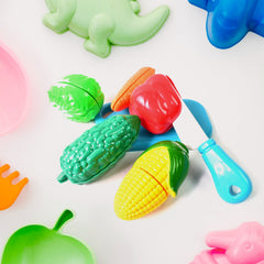 Child's hands holding a toy knife and slicing a toy banana on a cutting board