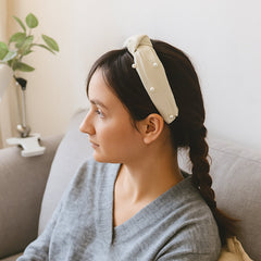 Woman wearing a stylish ribbed knot hairband, side view