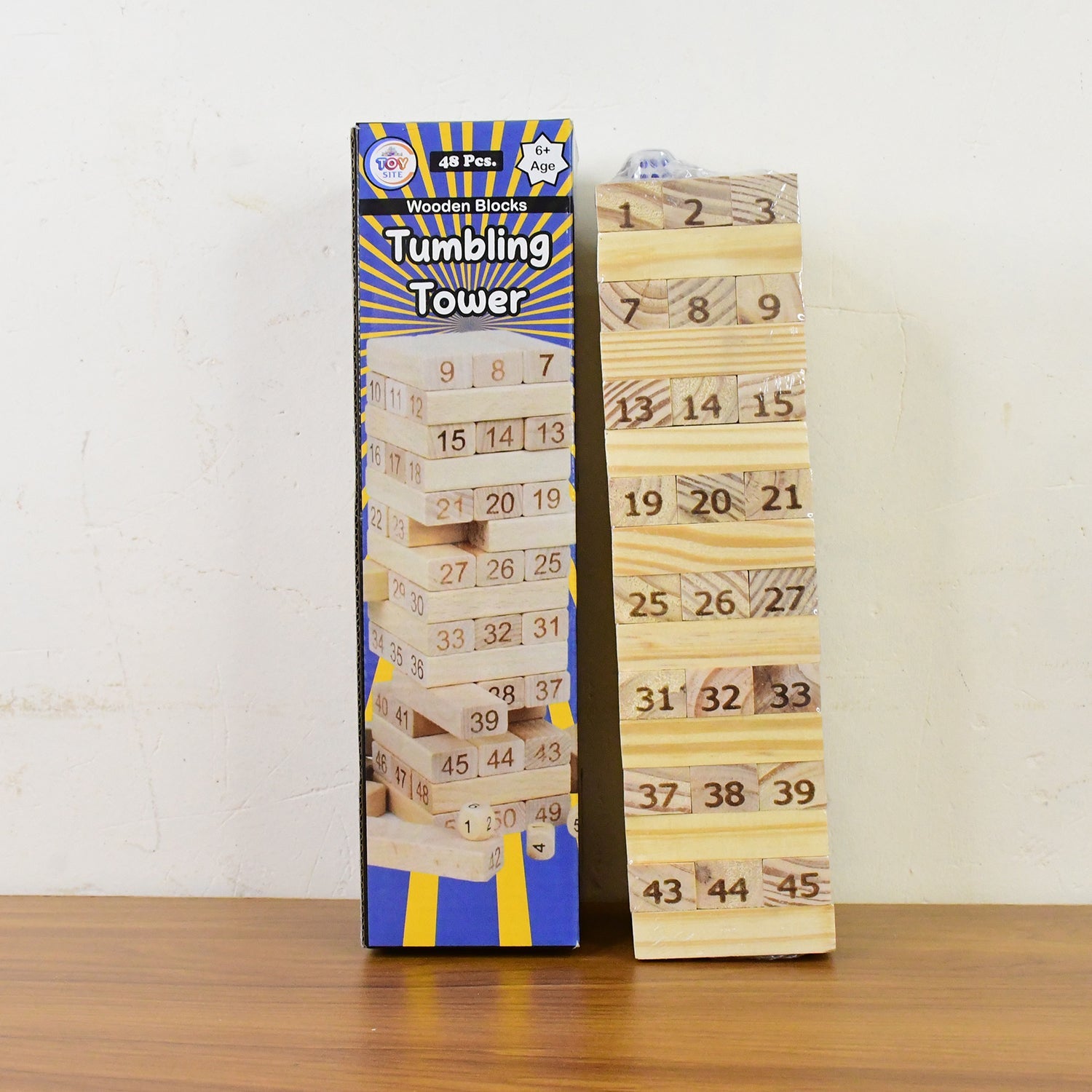 Wooden tumbling tower game blocks stacked outdoors on grass