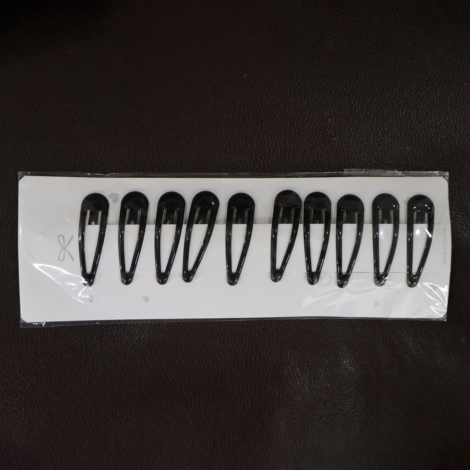 Matte finish metal hair clips held on hand for size reference
