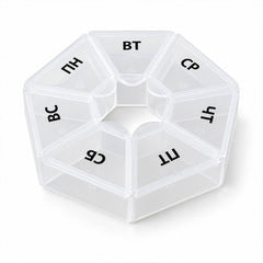 A clear hexagonal pill organizer with seven labeled compartments is centered on a white background.