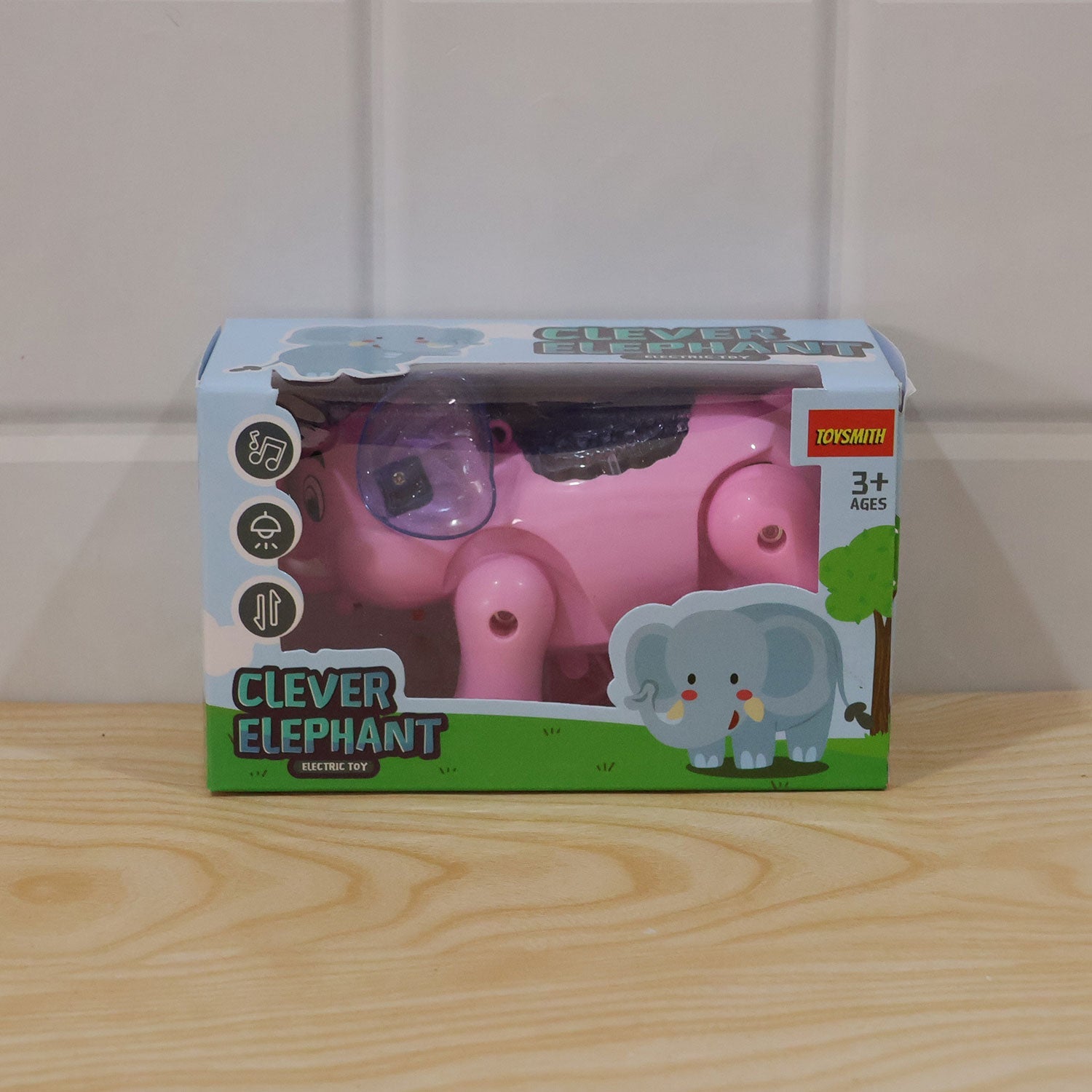 The pink elephant toy in its light blue and white