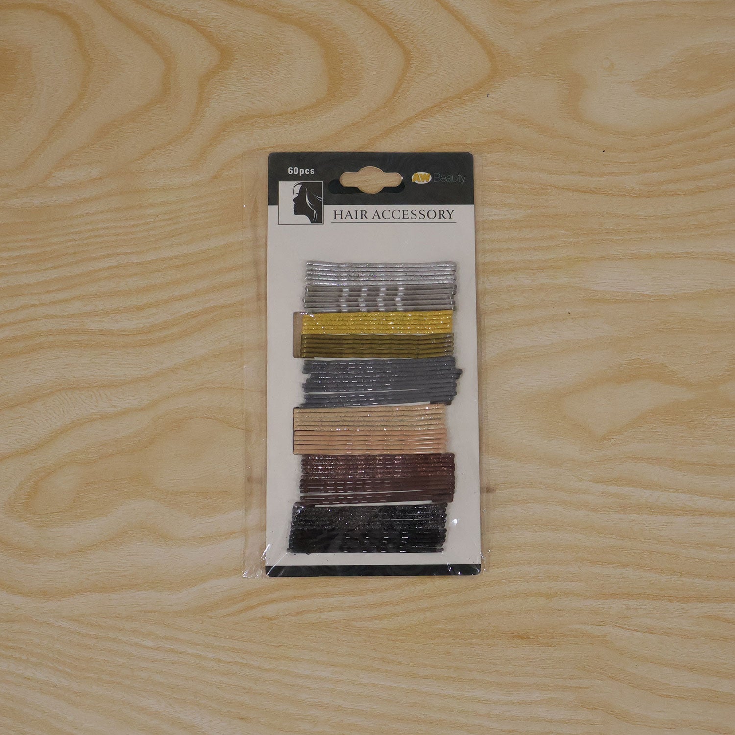 A package of 60 glittery hairpins in various colors lies flat on a light wooden surface.