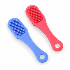 A blue and a pink silicone facial brush, both with textured bristles, lie side-by-side on a white surface.