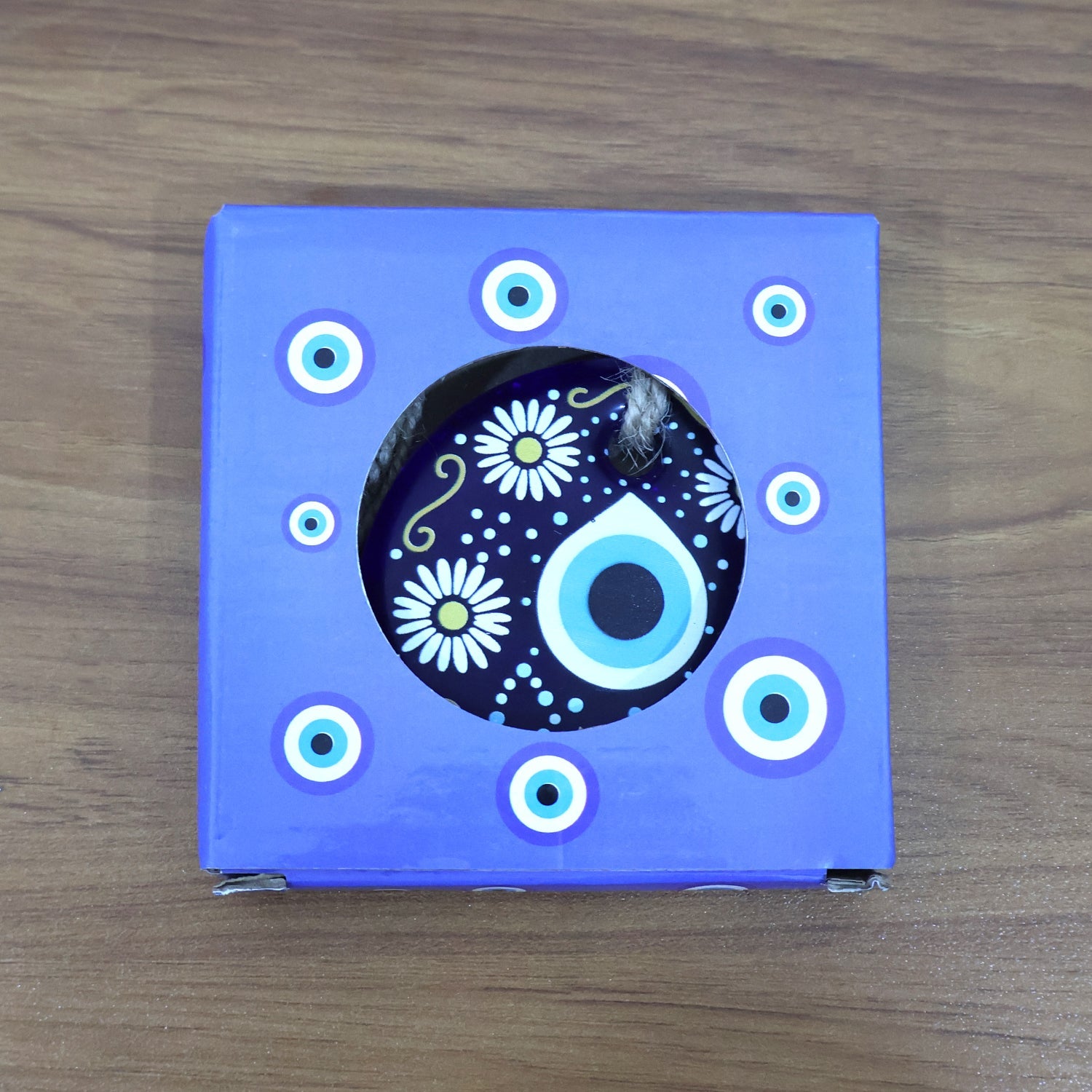 Evil eye wall hanging against a rustic wooden background