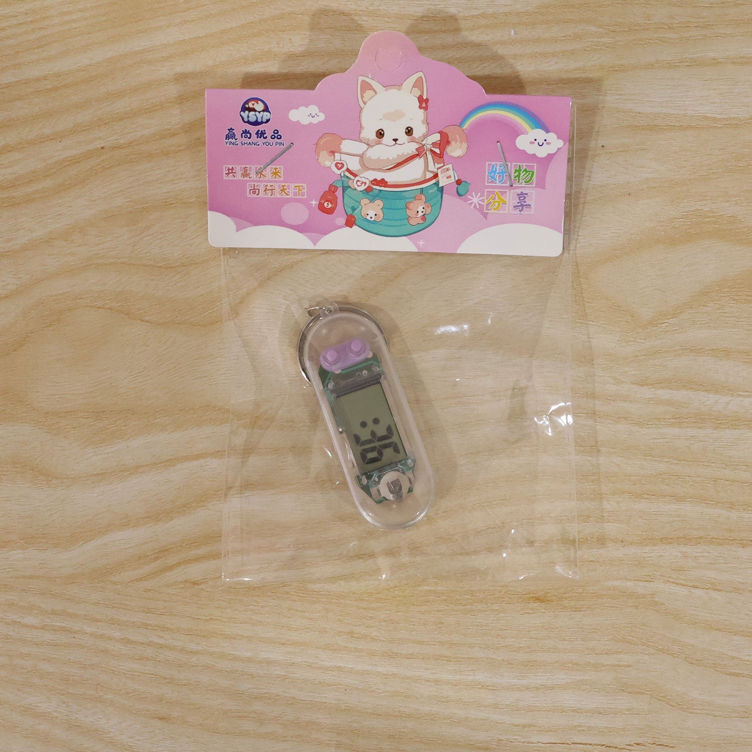 A transparent digital watch keychain sealed in a clear plastic retail pouch with a colorful cartoon header.