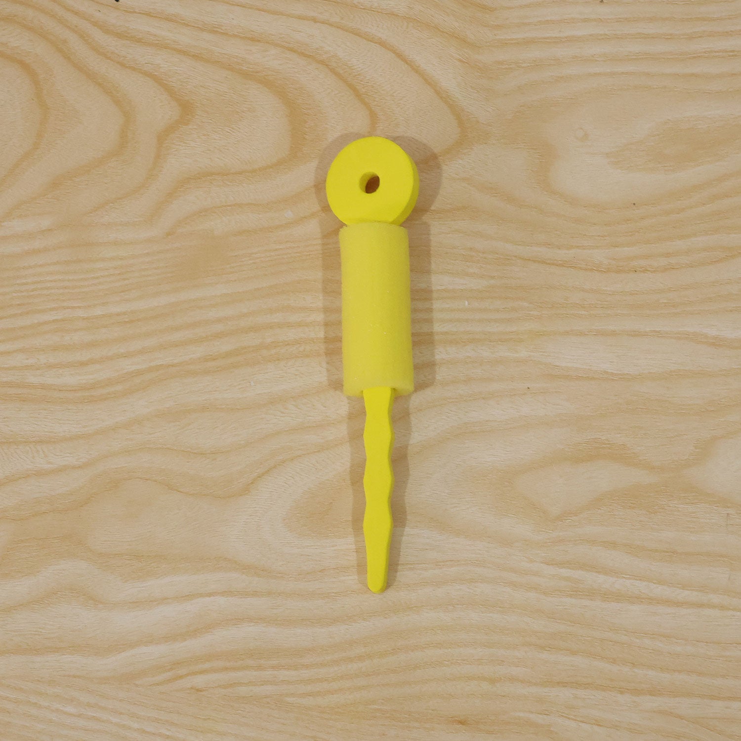 Person demonstrating the use of a yellow foam hair curling roller on hair