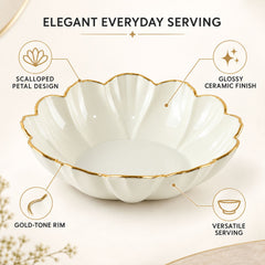 Empty white ceramic scalloped bowl with a gold rim, showing its glossy finish and petal design.