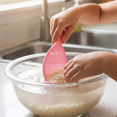 Strainer spoon rinsing rice under a tap