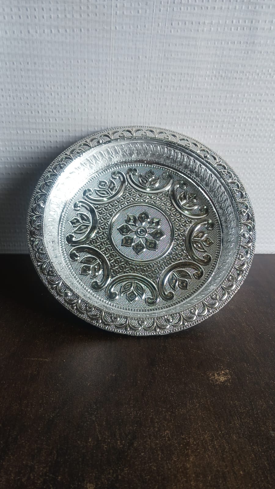 Side view of traditional silver finish plastic pooja thali