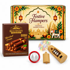 Overhead view of a festive hamper box, wafer rolls, string lights, and a silver coin.