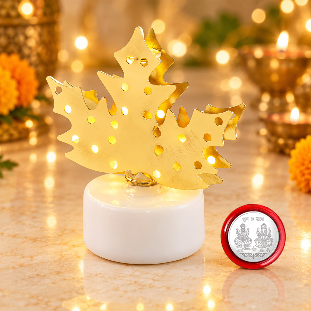 A close-up of a glowing golden maple leaf lamp on a white base next to a small silver coin.