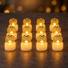 Twelve gold mesh LED tealights arranged in three rows on a dark surface, all emitting light.