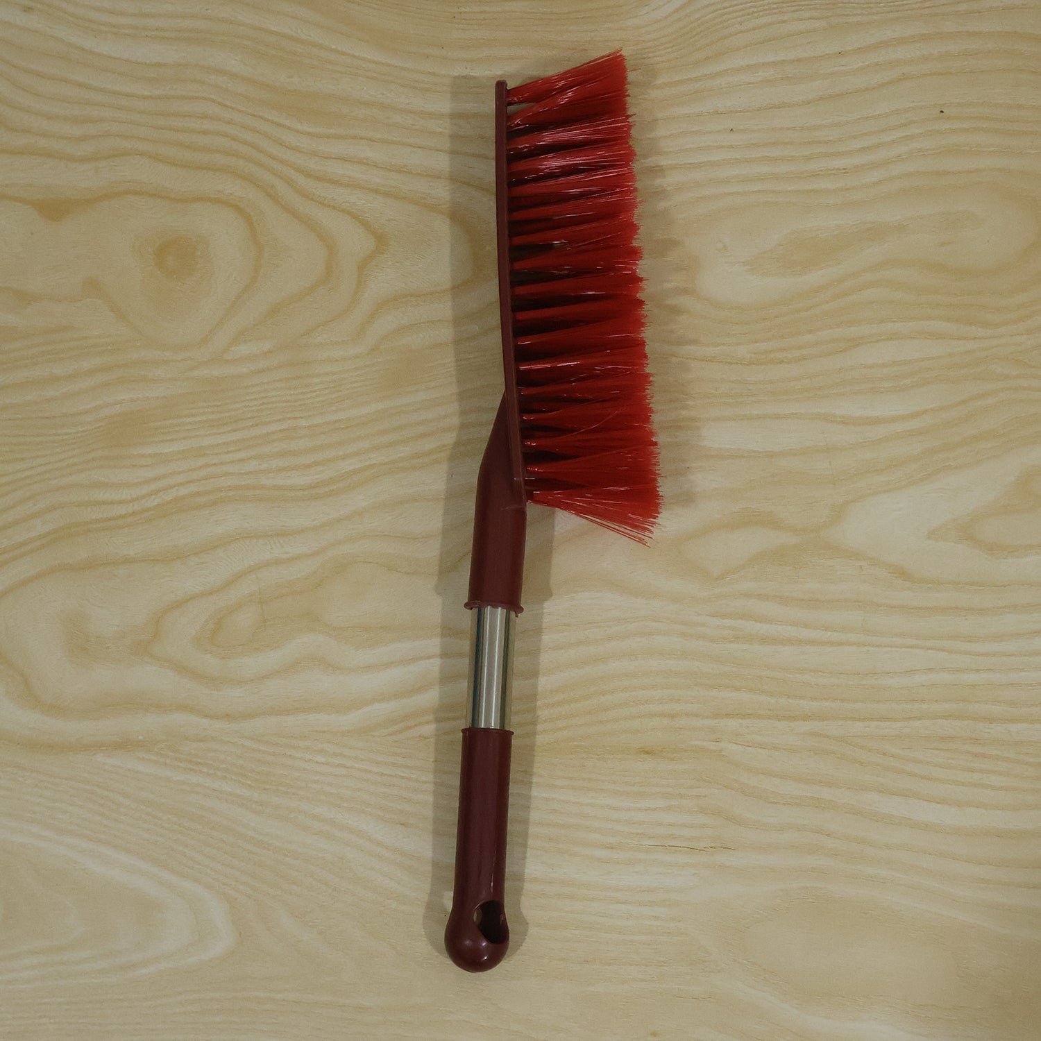 Red long handle cleaning brush in a home cleaning setting