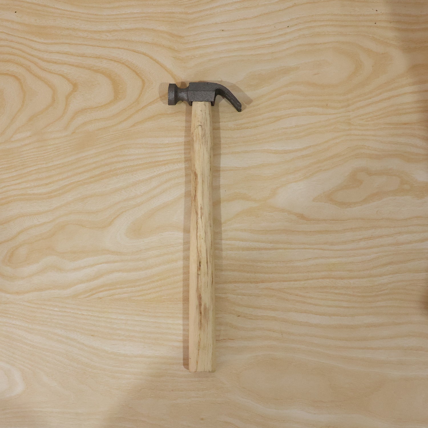 Person using claw hammer to drive a nail