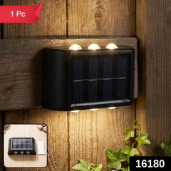 A black solar-powered LED wall light illuminates a wooden fence and green ivy at night, with a '1 Pc' label and '16180'