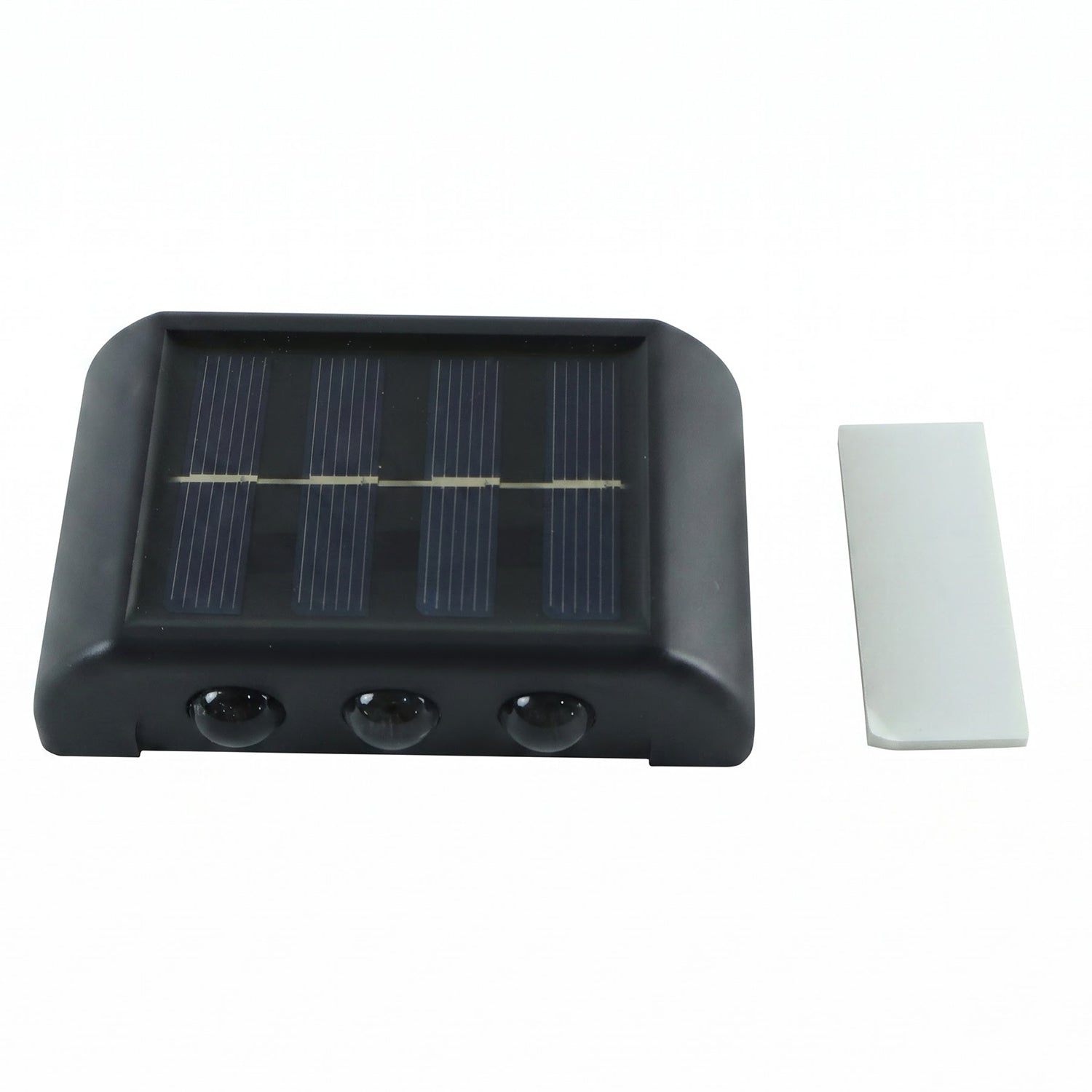 A black solar-powered LED wall light with a solar panel and three sensors, next to a white adhesive strip on a white