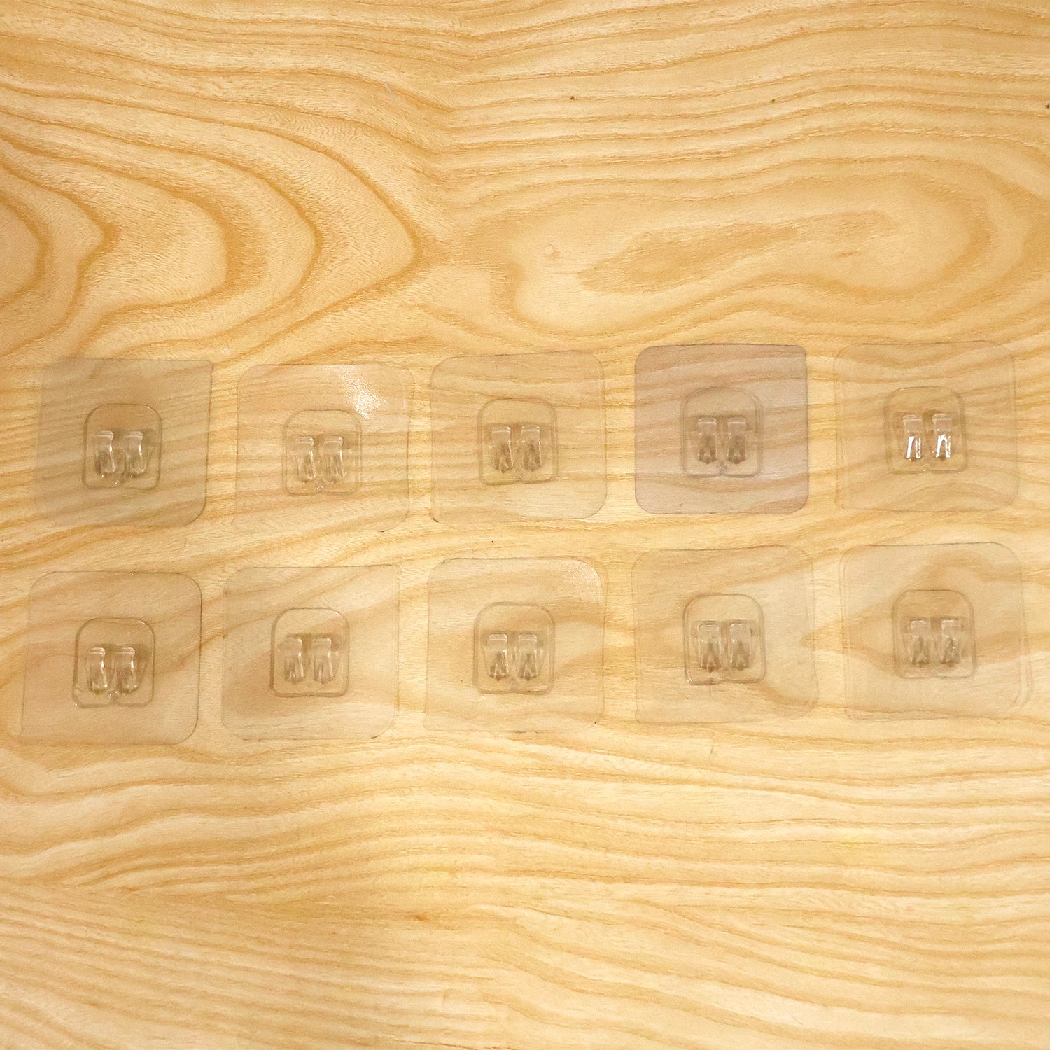 Self adhesive transparent hooks holding a lightweight bag on a wall