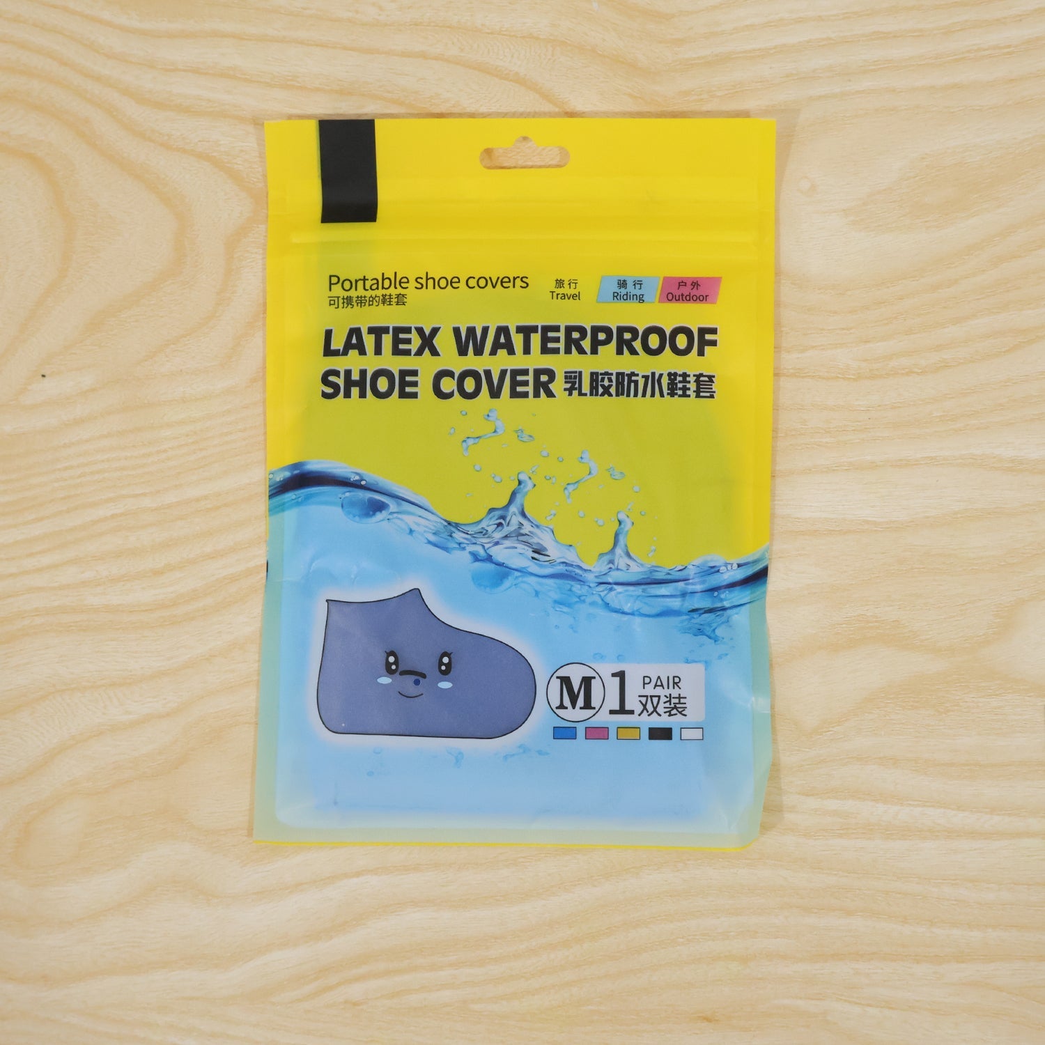 A yellow and blue package for "LATEX WATERPROOF SHOE COVER" with a cartoon shoe is on a wooden surface.