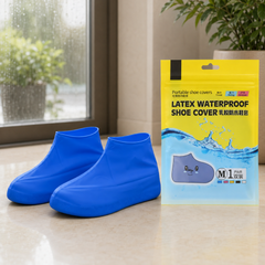 Two blue latex shoe covers next to a yellow and blue package for "Latex Waterproof Shoe Cover" on a tiled floor.