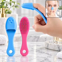 Two silicone facial brushes, one blue and one pink, stand upright on a marble counter next to a hand demonstrating use.