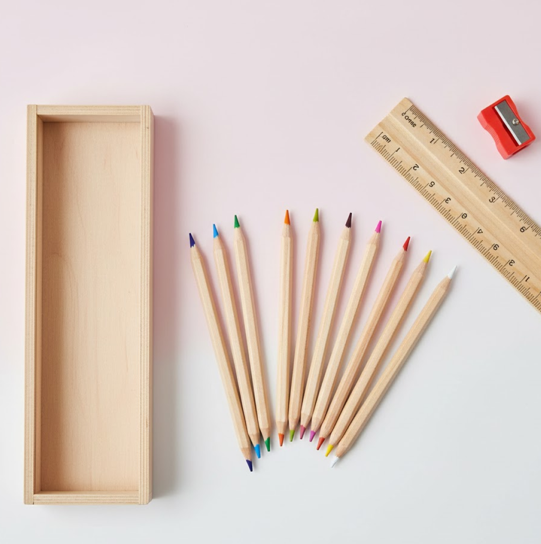 Colorful wooden pencils in a set with a pencil box, ruler, and sharpener.