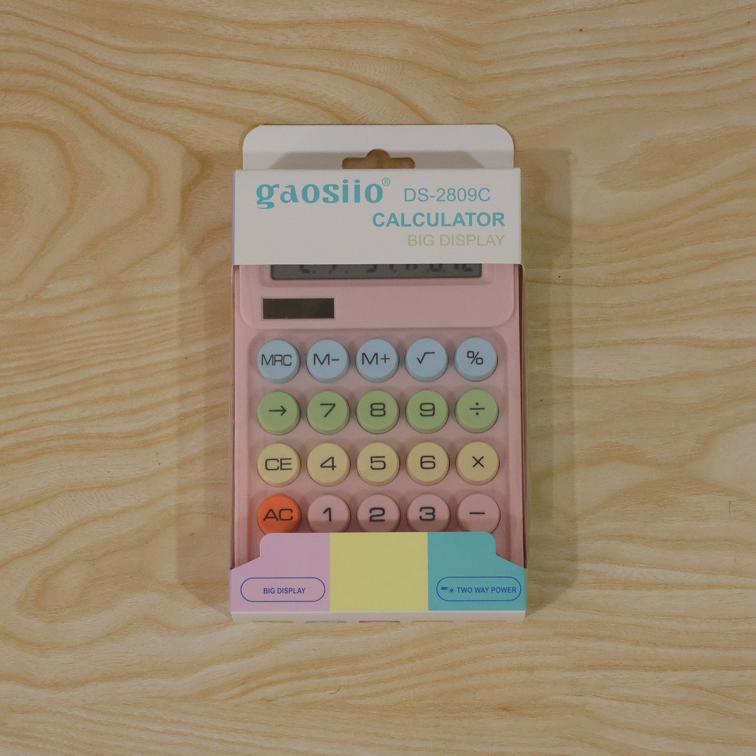 A pink calculator in its white and colorful retail packaging, featuring the brand "gaosiio" and product name, rests on a