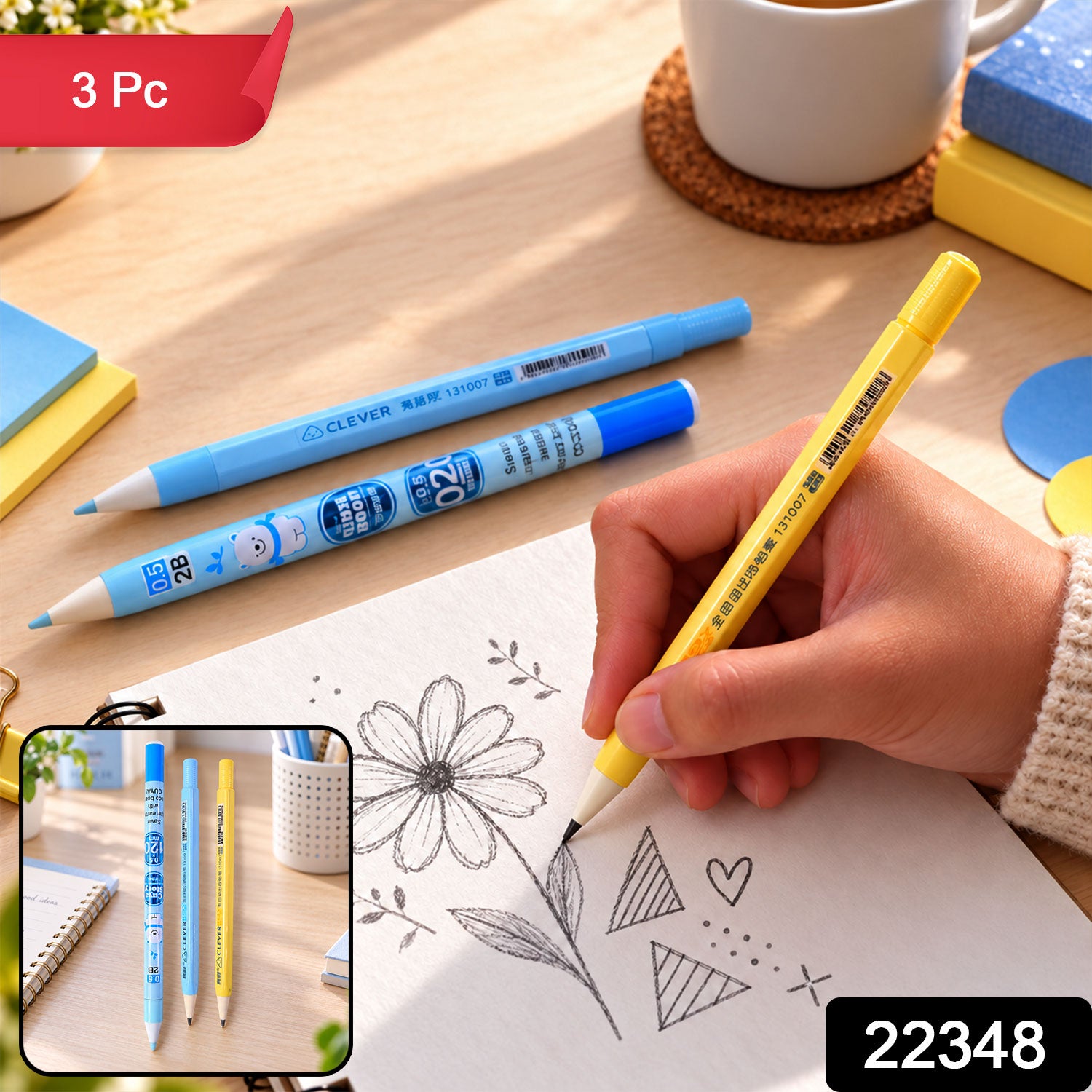 A hand holds a yellow mechanical pencil, drawing on white paper with two blue pencils on a wooden desk.