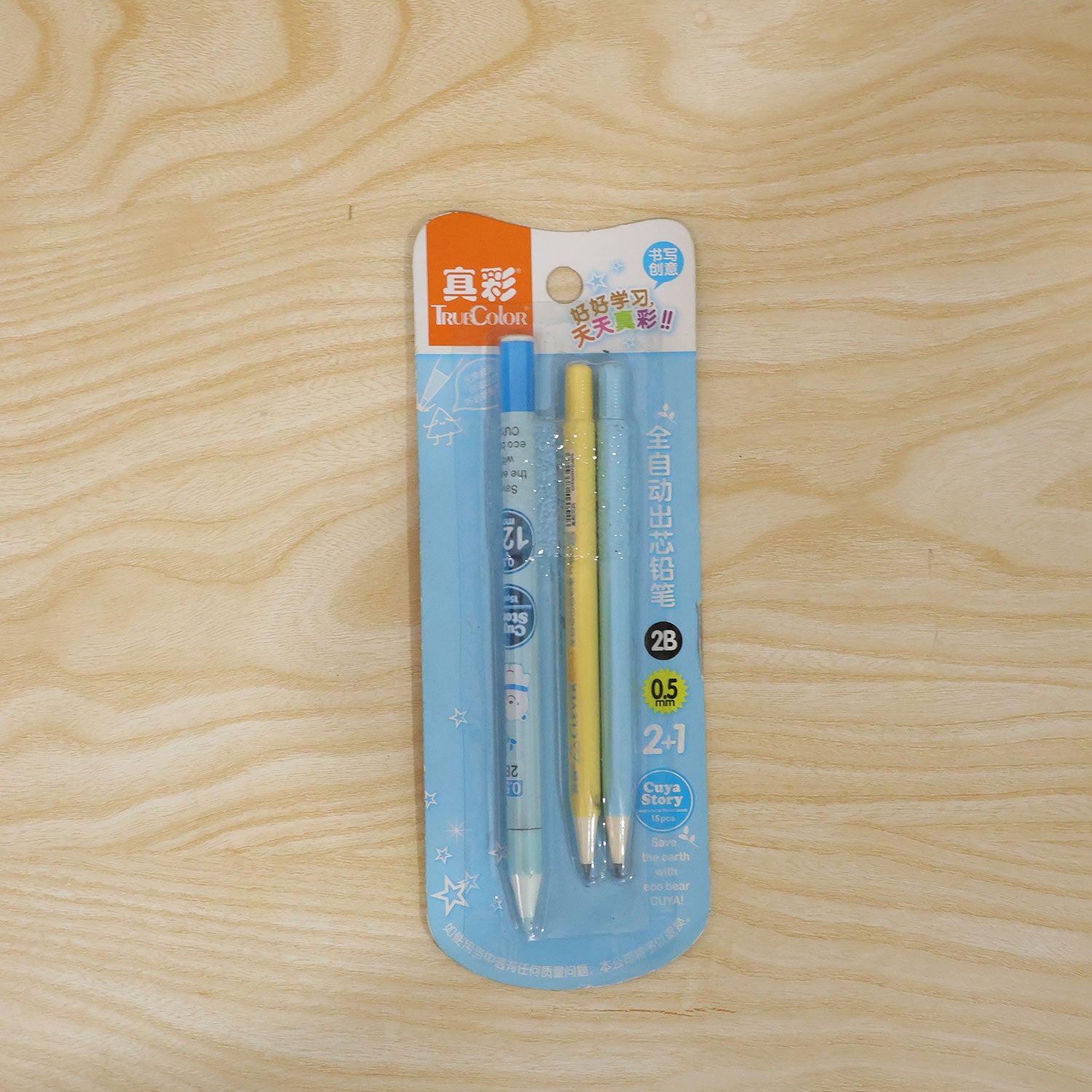 A two-pack of mechanical pencils, one blue and one yellow, sealed in clear plastic packaging on wood.