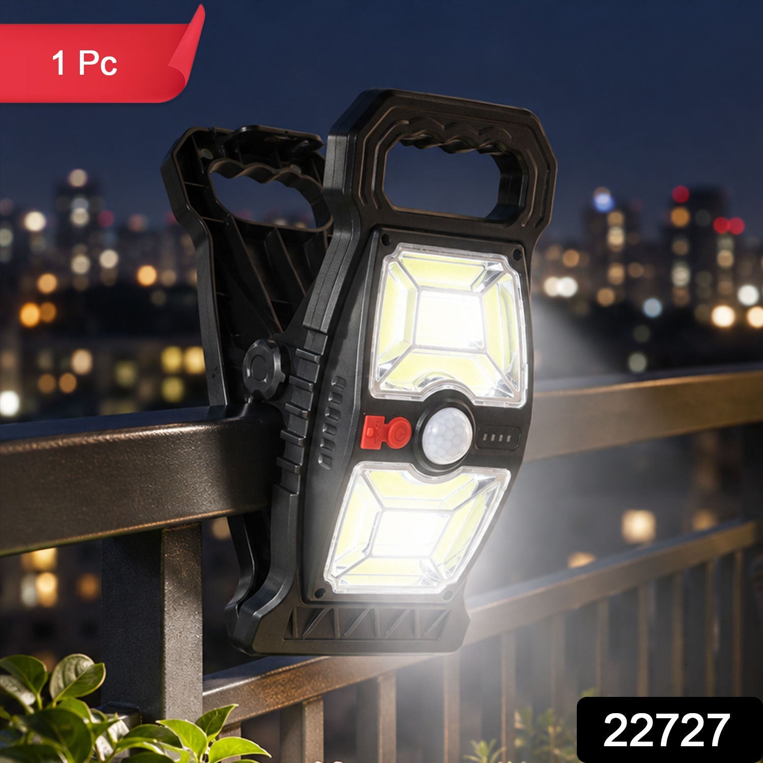 A black solar motion sensor clip light with a red power button and white lights is clipped to a dark railing.