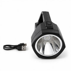 A black handheld torch with a silver reflector and a short black USB-C charging cable on a white surface.