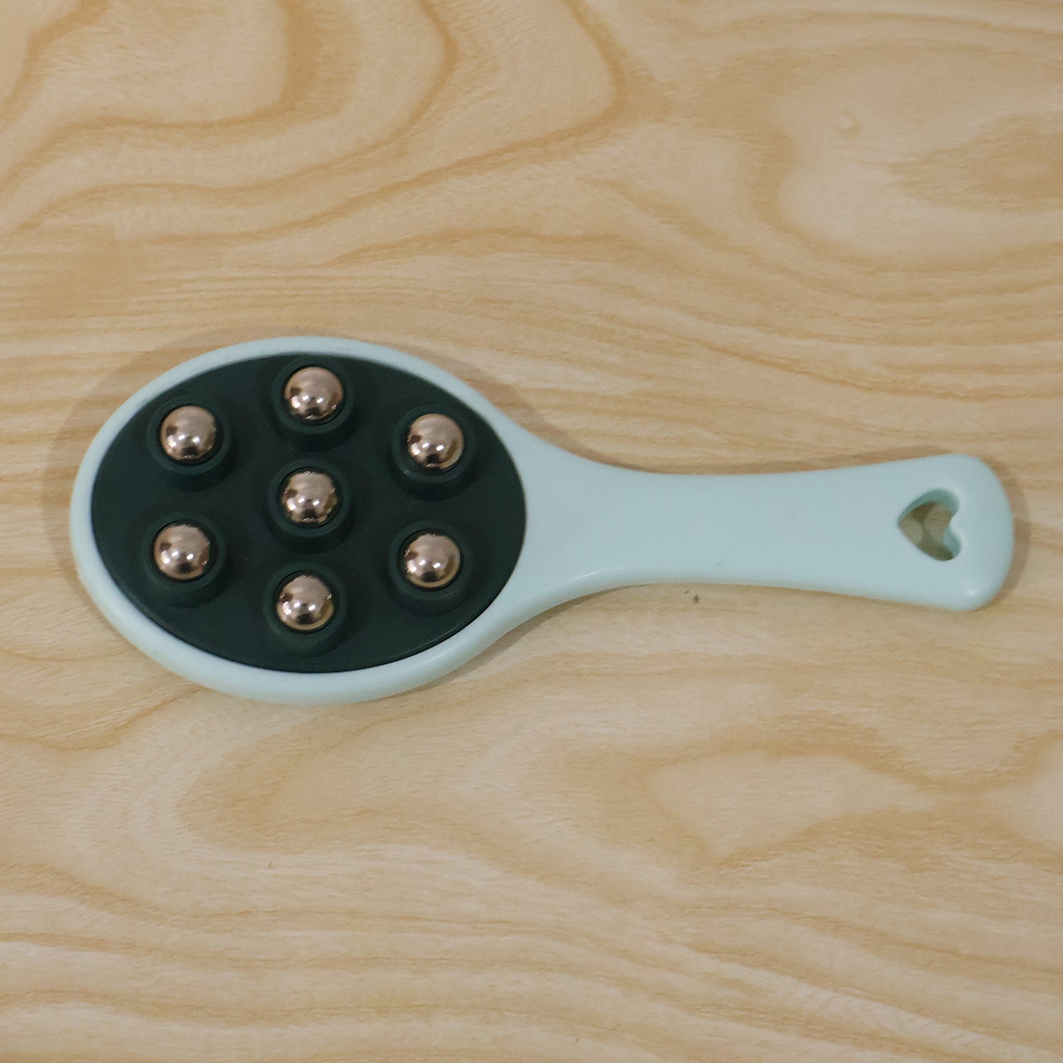 Handheld roller ball massager in its retail packaging.