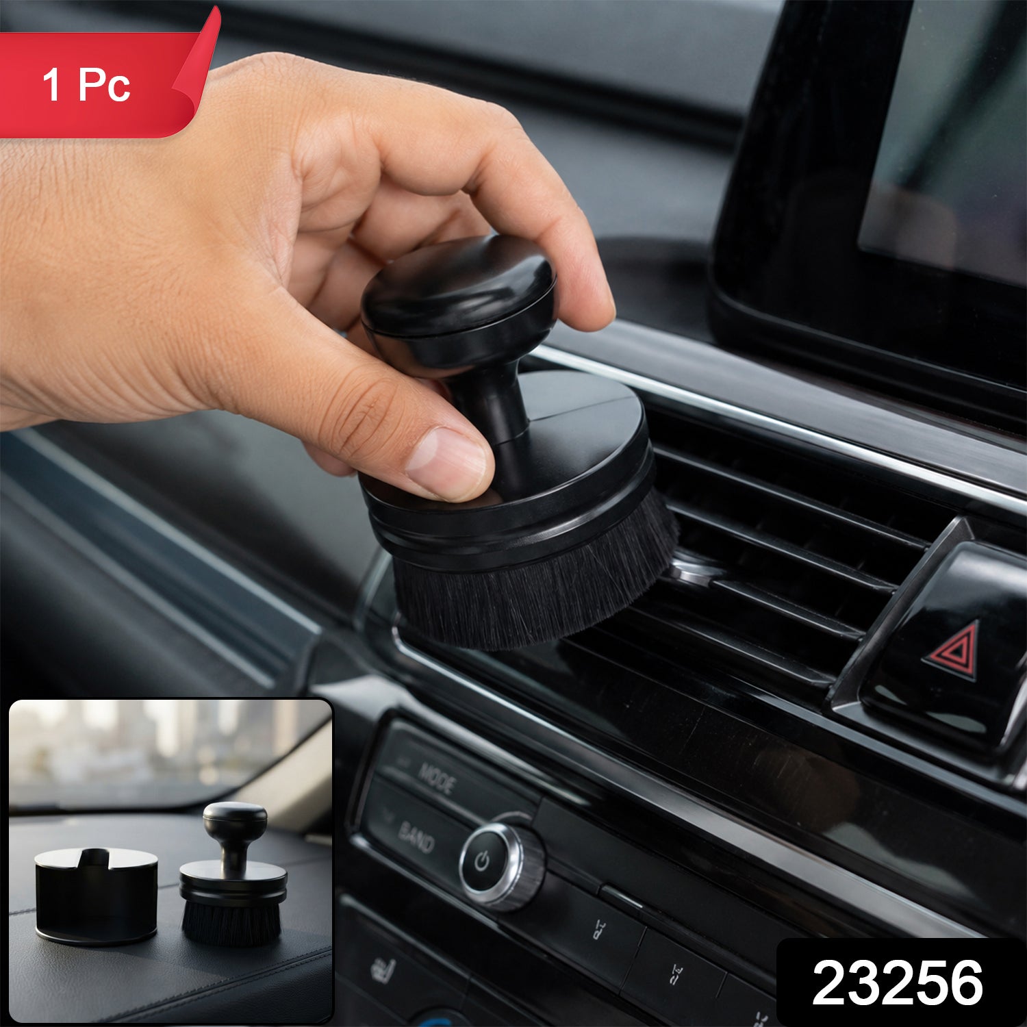 A hand holds a black detailing brush, cleaning a car's air vent, with a small inset showing the brush and its base â€“ view 2