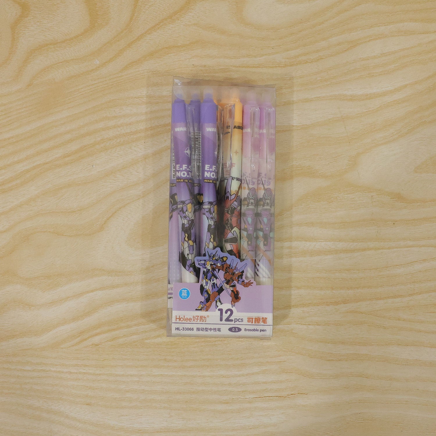 A clear box of twelve anime-themed gel pens in various colors, placed on a light wooden surface.