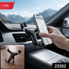 A hand placing a phone into a black gravity lock car phone holder mounted on a car's air vent, with a smaller inset image of