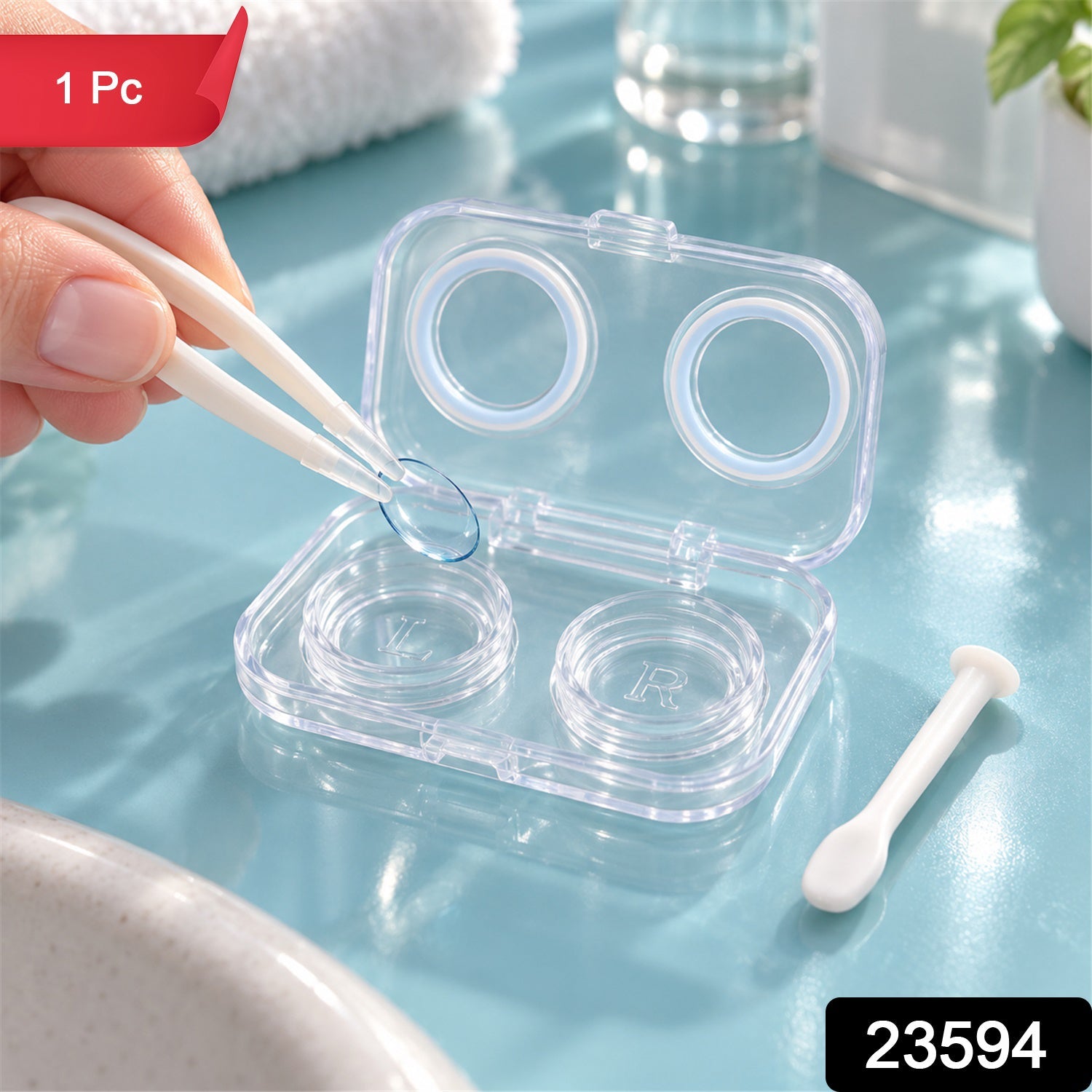 A hand uses white tweezers to place a blue contact lens into an open clear case on a blue surface.