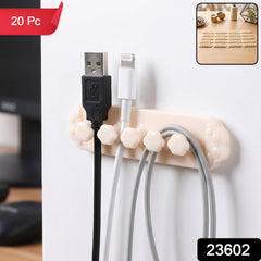 A beige self-adhesive cable organizer clip with five flower-shaped holders, securing black, white, and gray USB â€“ view 2