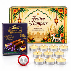 A festive hamper box, a small box of wafer rolls, and nine lit tea light candles are arranged on a marble surface â€“ view 2