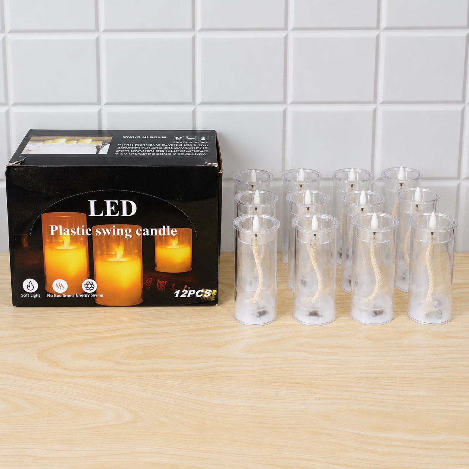 A product box for LED swing candles sits on a light wooden surface, next to twelve clear plastic tubes without their flames
