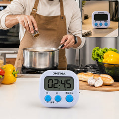 A white digital kitchen timer with blue buttons sits on a kitchen counter, displaying 02:45, with a person cooking in the