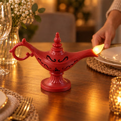A red Aladdin's lamp LED light glows on a wooden table set with plates, a glass, and a small votive candle holder.