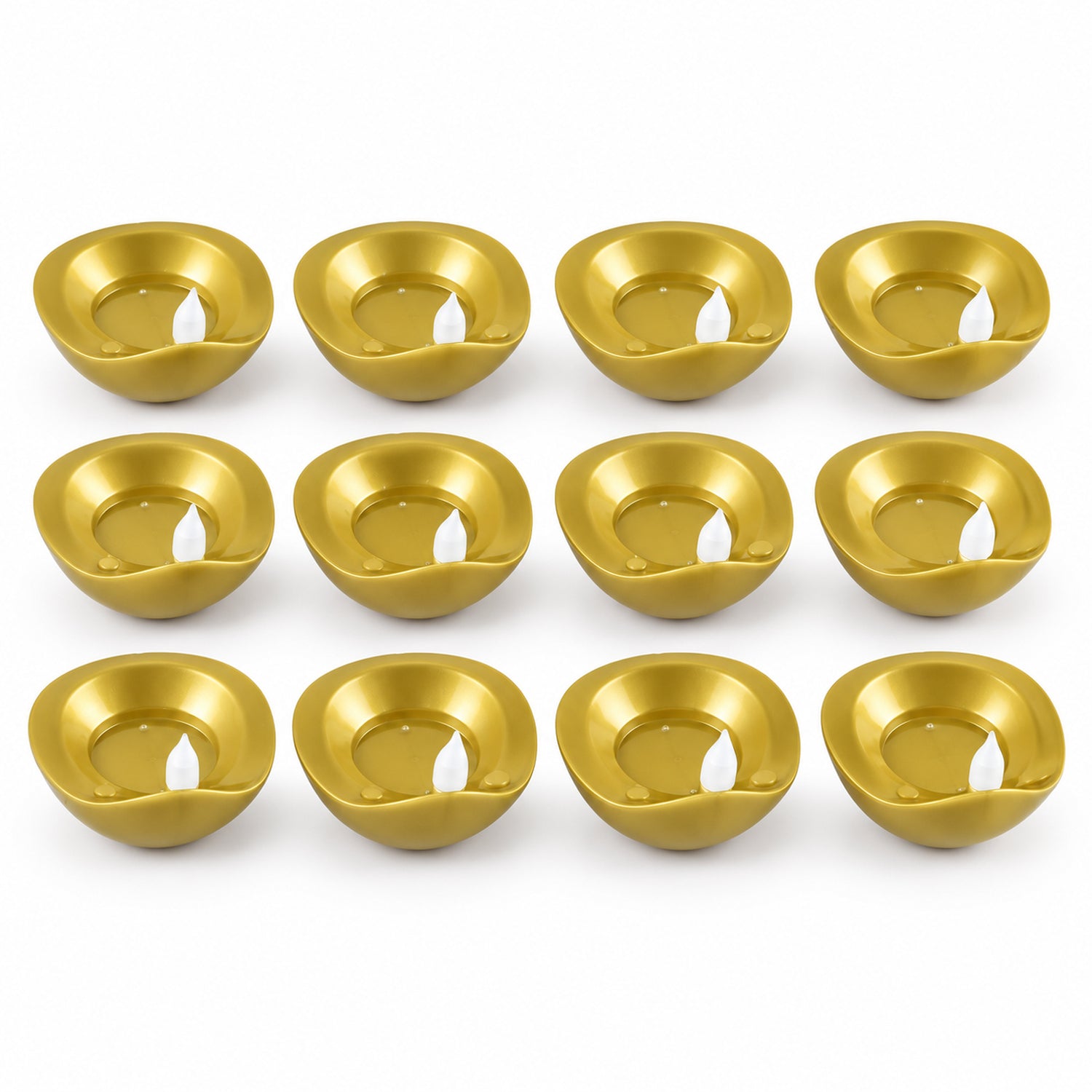Twelve unlit golden diyas with white plastic wicks are neatly arranged in four rows on a white surface.