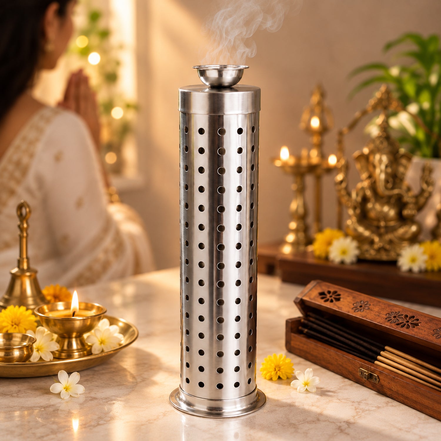 A tall, silver perforated incense holder releases smoke, positioned on a table with offerings and a person in traditional