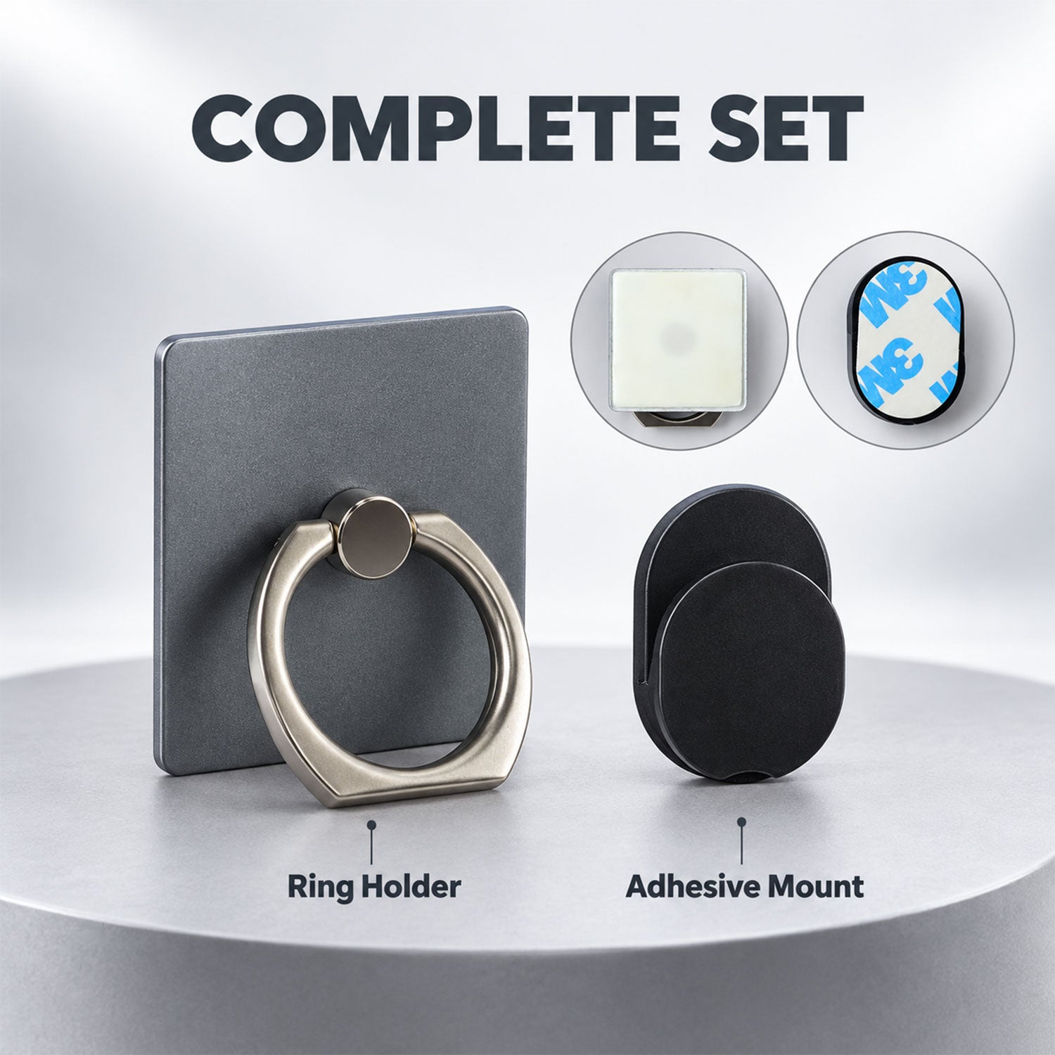 The gray phone ring holder and the black adhesive car mount are placed side-by-side on a light wooden surface.