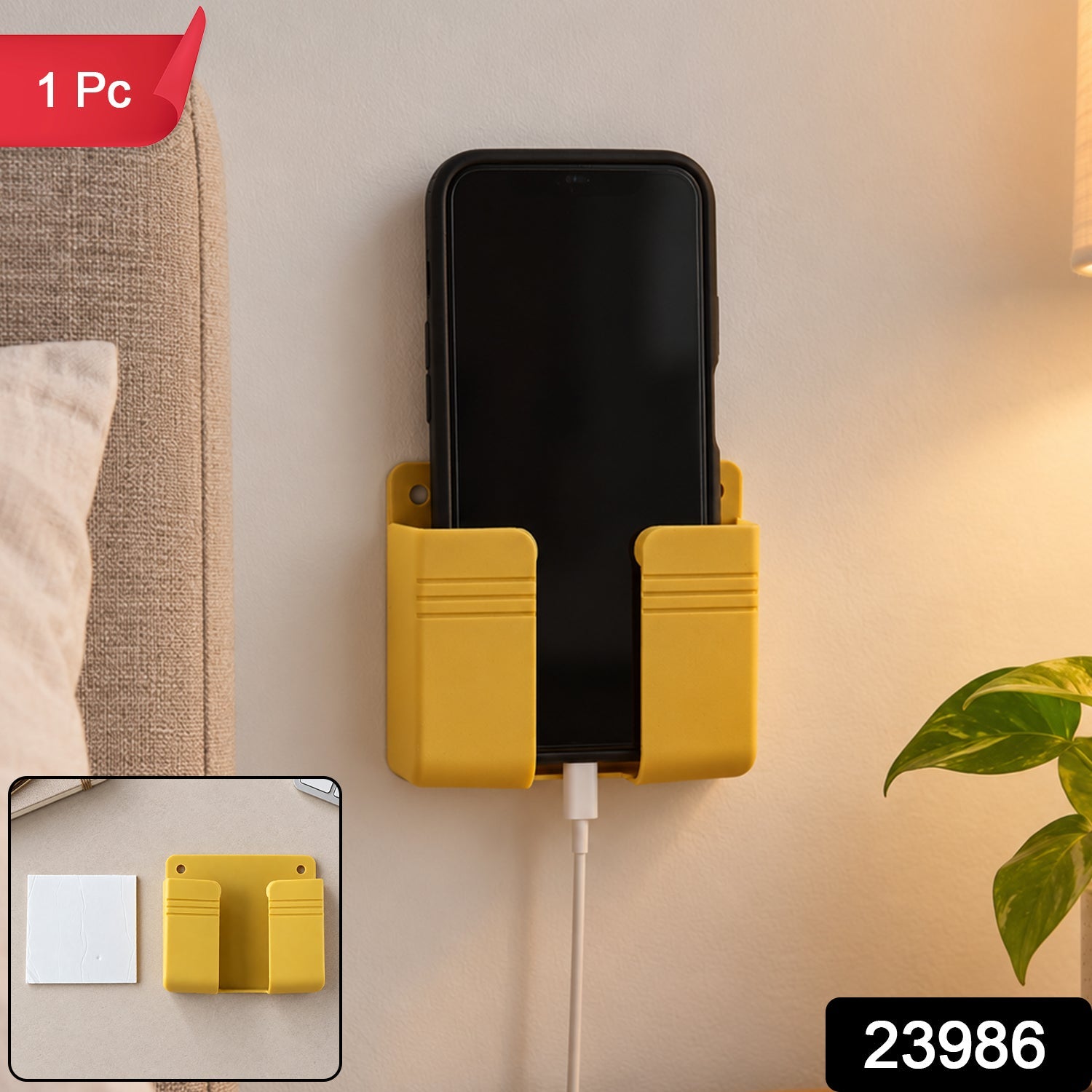 A yellow wall-mounted phone holder with a black phone charging, a small inset showing the holder and adhesive.