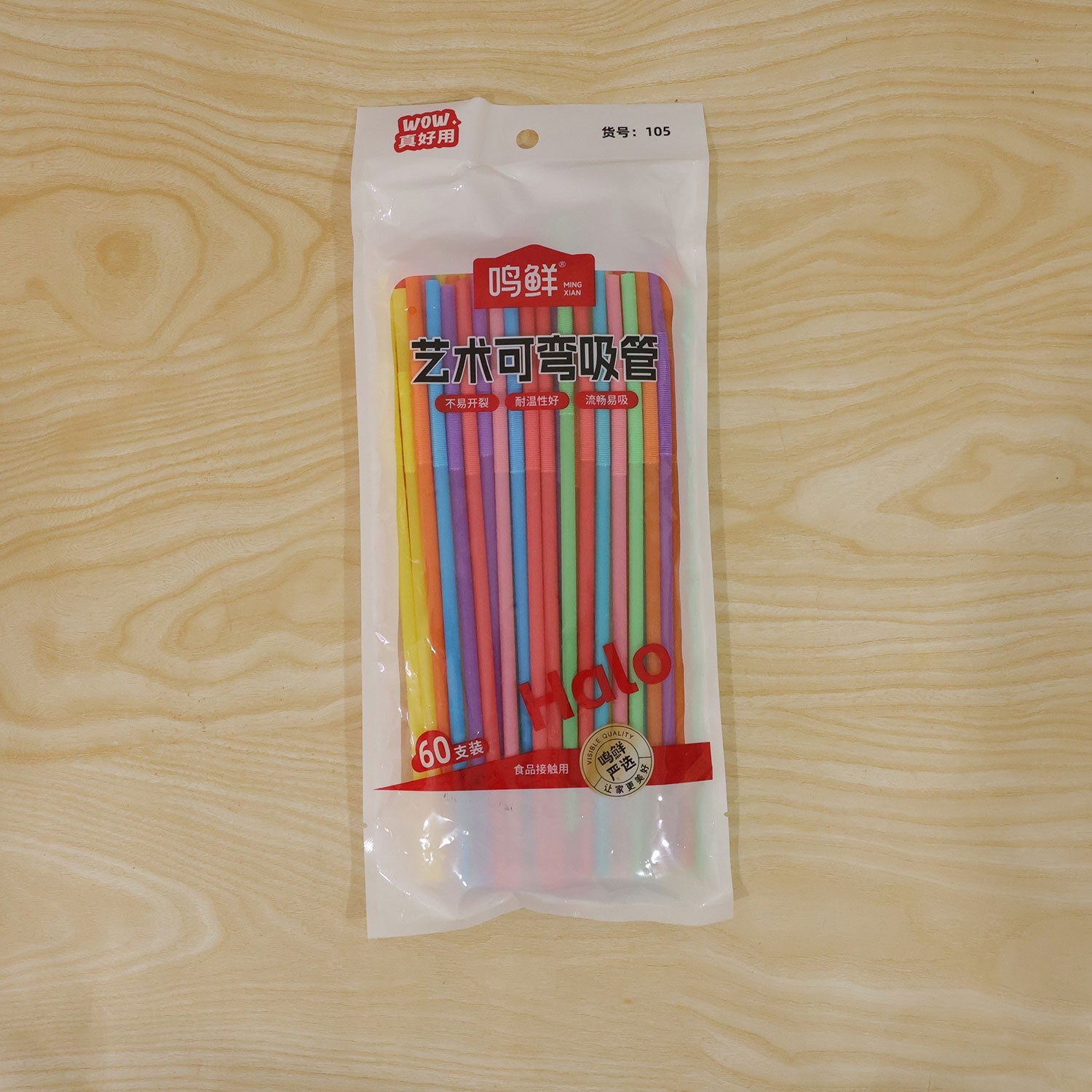 A clear plastic bag containing 60 colorful bendable drinking straws, displayed flat on a light wooden surface.