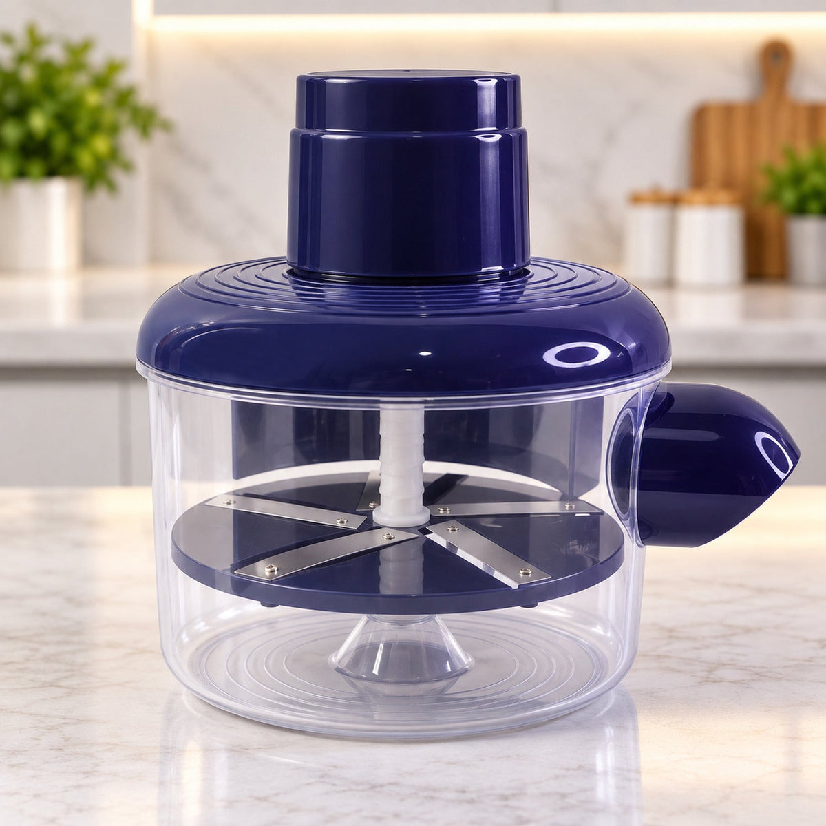 A dark blue and clear plastic automatic peeler with steel blades on a white marble counter.