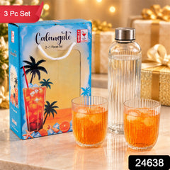A blue gift box with a tropical design sits beside a clear ribbed glass bottle and two matching tumblers filled â€“ view 2
