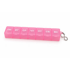 A pink plastic weekly pill box with seven compartments, each labeled with a Cyrillic day, with a silver ball chain attached