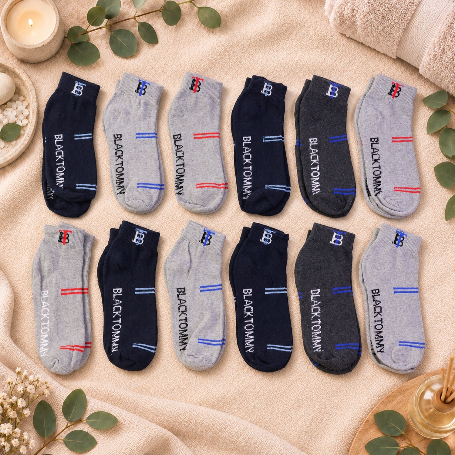 Twelve pairs of ankle socks in various colors and stripe combinations are arranged on a textured blanket.
